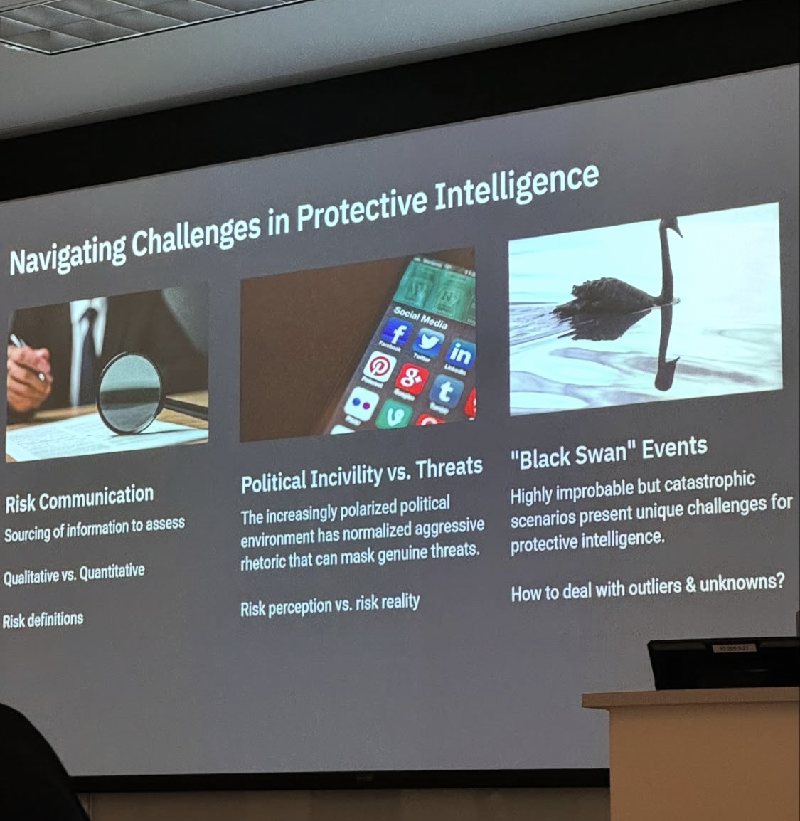 A conference slide on the challenges in protective intelligence, projected to a room.