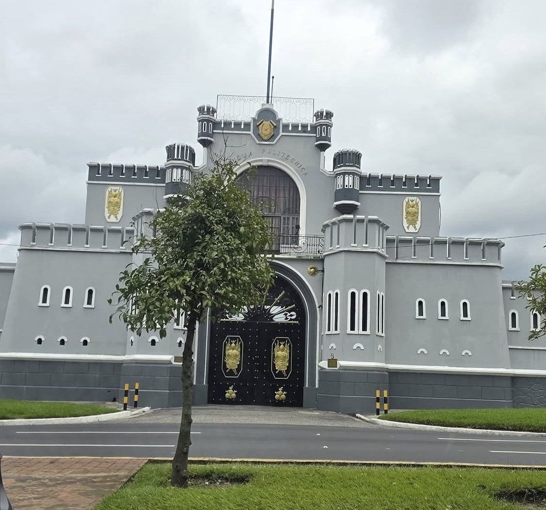 A guarded government compound seen from a vehicle in a Central American city.
