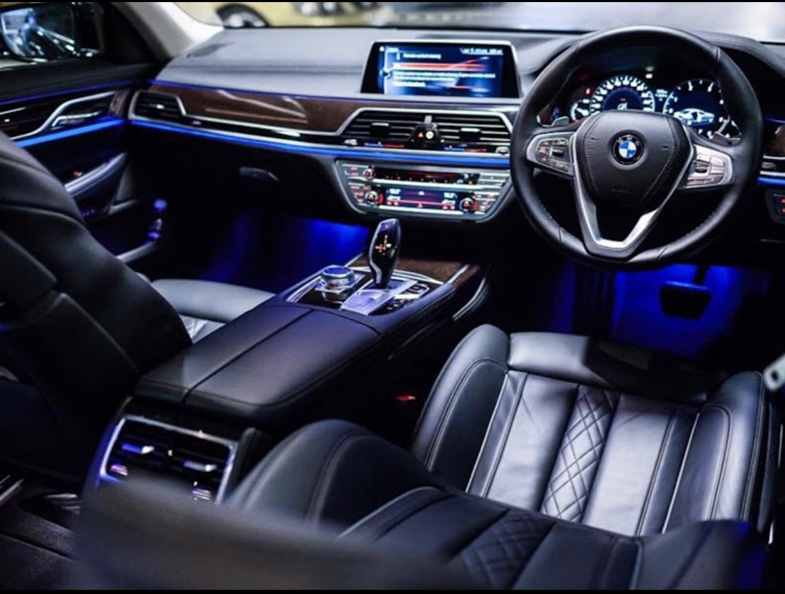 The interior of an executive vehicle at night, ambient lighting on, ready to move.