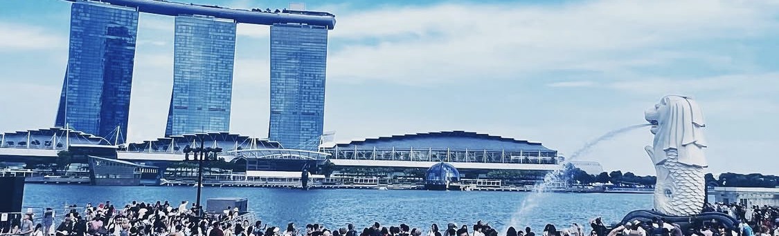 Marina Bay in Singapore across the water, crowds along the waterfront promenade.